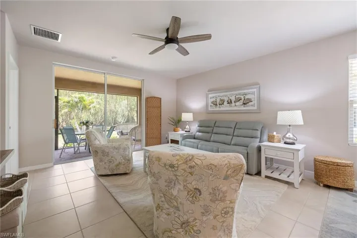 Tiled flooring extends into a screened outdoor living area through sliding glass doors, creating an open indoor-outdoor atmosphere