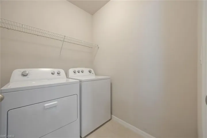 Laundry area featuring a wire shelf, light neutral wall paint, and baseboard trim