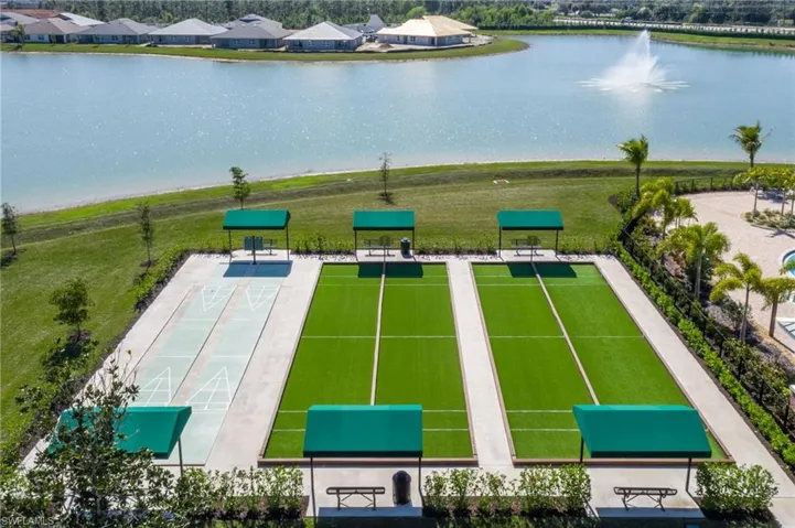 Recreational area featuring artificial turf bocce ball courts and concrete shuffleboard courts, each with covered seating