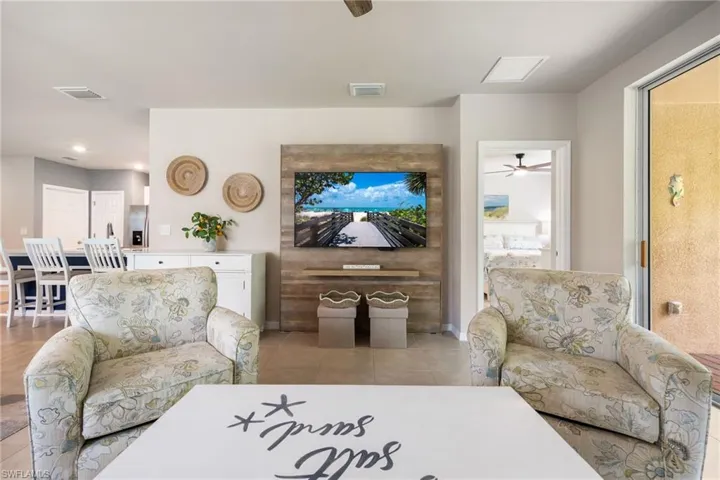 Open-concept living space featuring neutral wall tones, recessed lighting, and tile flooring