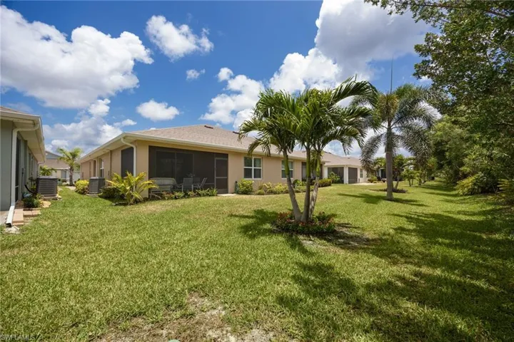 Expansive green lawn featuring mature palm trees and additional landscaping