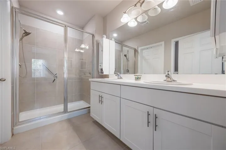 Bathroom featuring a double vanity with white cabinetry and integrated sinks