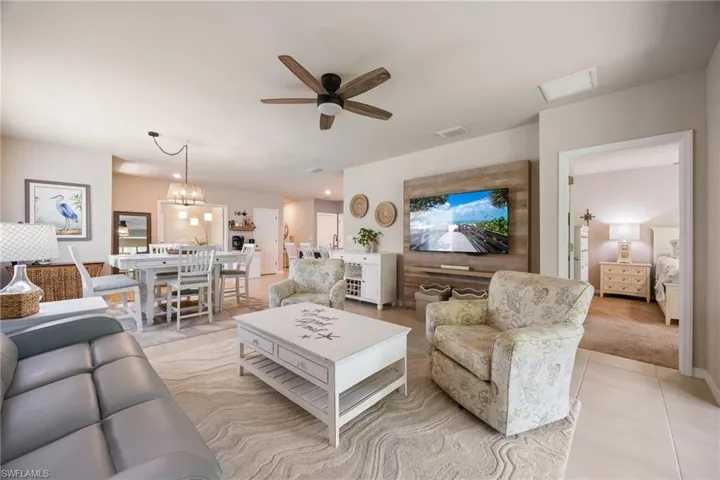 Open-concept living area with tile flooring and a wood-finish ceiling fan