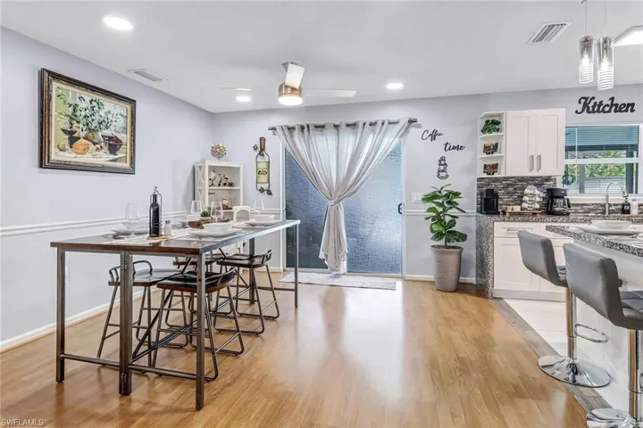 Dining room with light wood finished floors, a ceiling fan, recessed lighting, and baseboards