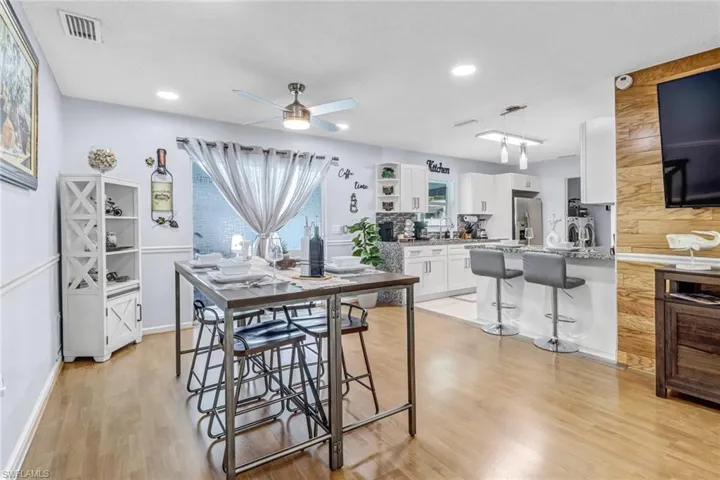 Dining area with a ceiling fan, light wood-style floors, recessed lighting, and baseboards