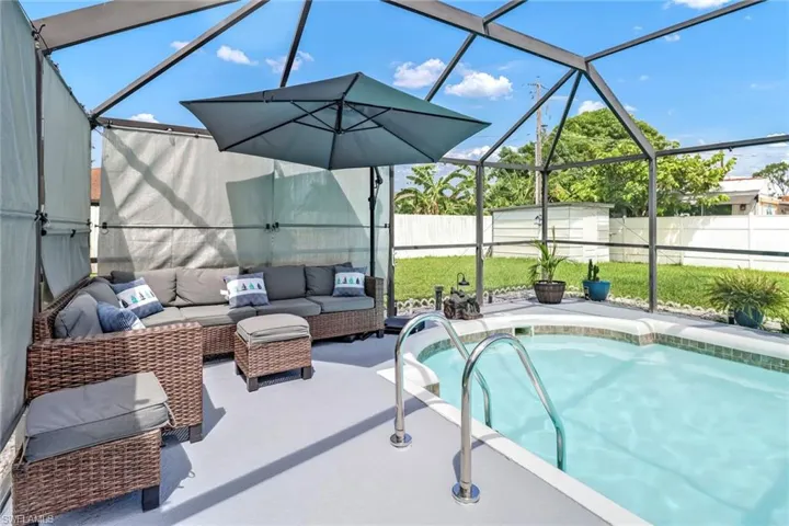 View of swimming pool with outdoor lounge area, a fenced backyard, a patio area, and glass enclosure