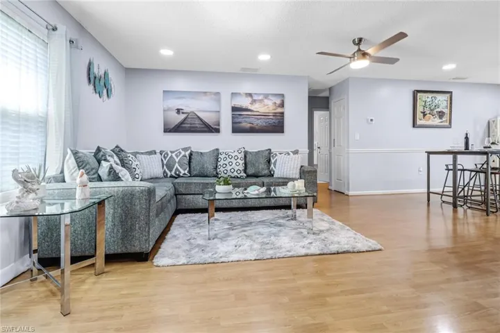 Living area with ceiling fan, wood finished floors, baseboards, and recessed lighting