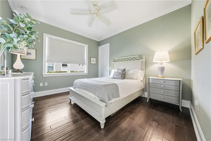 Spacious guest bedroom with hardwood looking tile flooring
