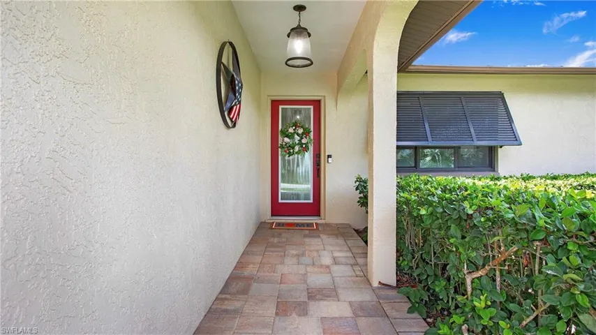 Covered front entryway leads to beautiful impact glass front door