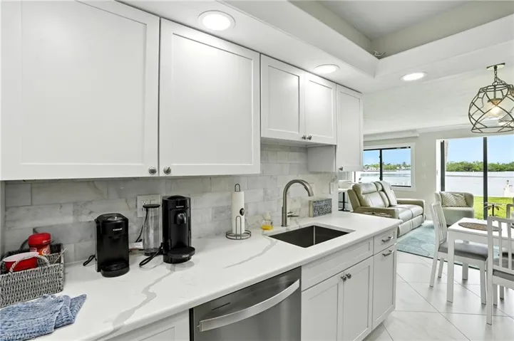 Kitchen with recessed lighting, white cabinets, tasteful backsplash, stainless steel dishwasher, and light tile patterned floors