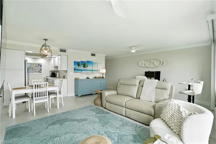 Living room with crown molding and baseboards