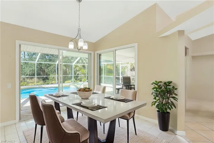 Virtual Staged Dining room featuring baseboards, a sunroom, light tile patterned flooring, and vaulted ceiling