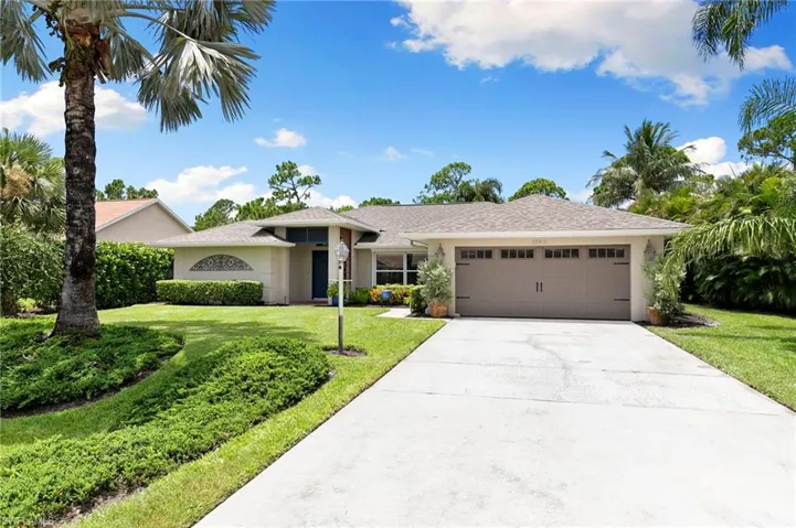 Ranch-style home with an attached garage, a front lawn, concrete driveway, and stucco siding
