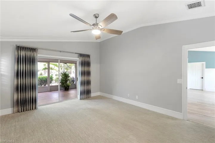 Unfurnished room featuring ornamental molding, lofted ceiling, light carpet, and a ceiling fan