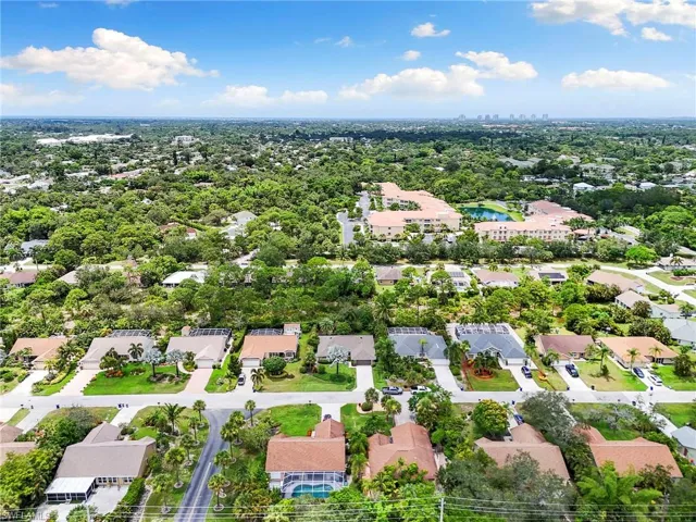 Aerial perspective of suburban area featuring a nearby body of water and city skyline