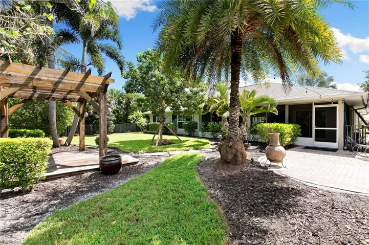 View of yard featuring a pergola, a patio area, and a sunroom