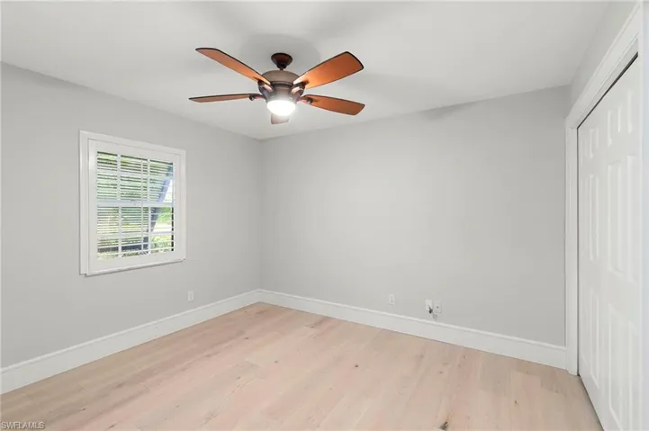 Unfurnished bedroom featuring light wood-style flooring, a closet, and ceiling fan