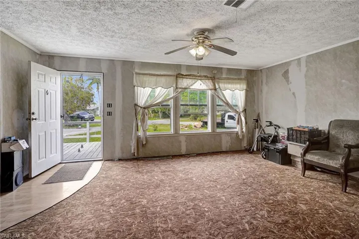 Walls are prepped for paint and carpet has been pulled up.