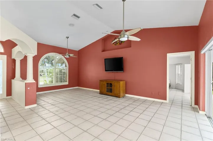 Unfurnished living room with ceiling fan, light tile patterned flooring, and high vaulted ceiling