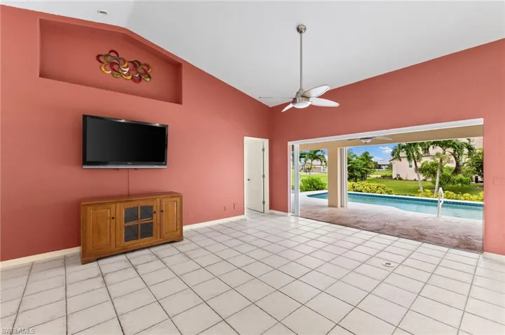 Unfurnished living room featuring ceiling fan, high vaulted ceiling, and light tile patterned floors