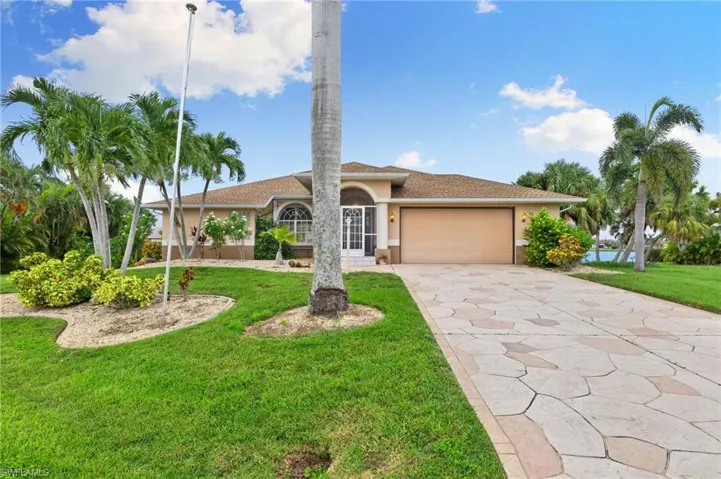 Mediterranean / spanish home with a front yard and a garage