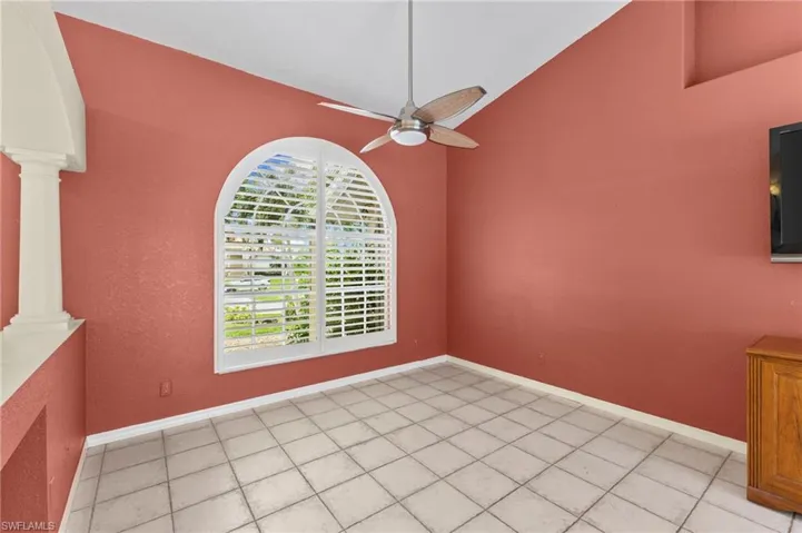 Unfurnished dining area featuring ceiling fan, light tile patterned flooring, high vaulted ceiling, and ornate columns