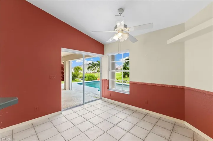 Tiled spare room with ceiling fan and vaulted ceiling