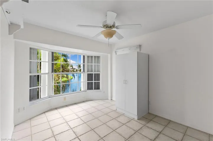 Tiled empty room with ceiling fan