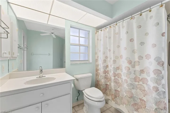 Bathroom featuring ceiling fan, vanity, toilet, and tile patterned flooring