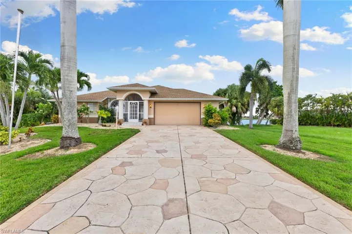 Mediterranean / spanish house featuring a garage and a front lawn
