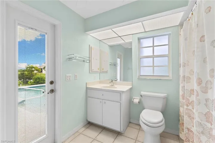 Bathroom with toilet, tile patterned floors, and vanity
