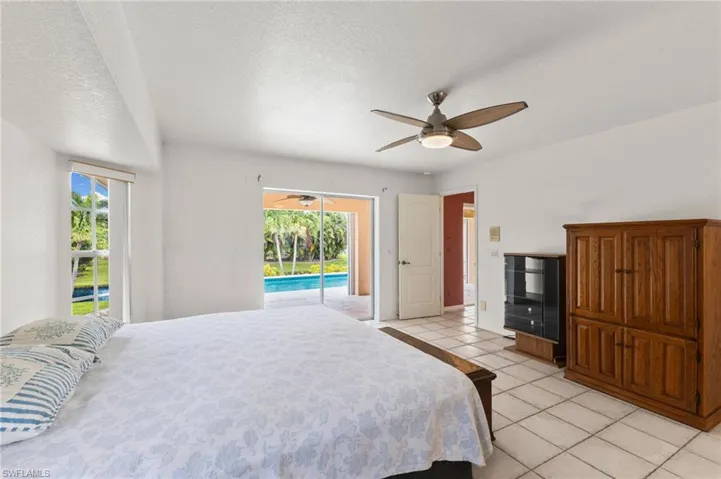 Primary Bedroom featuring access to outside, light tile patterned flooring, ceiling fan, and multiple windows