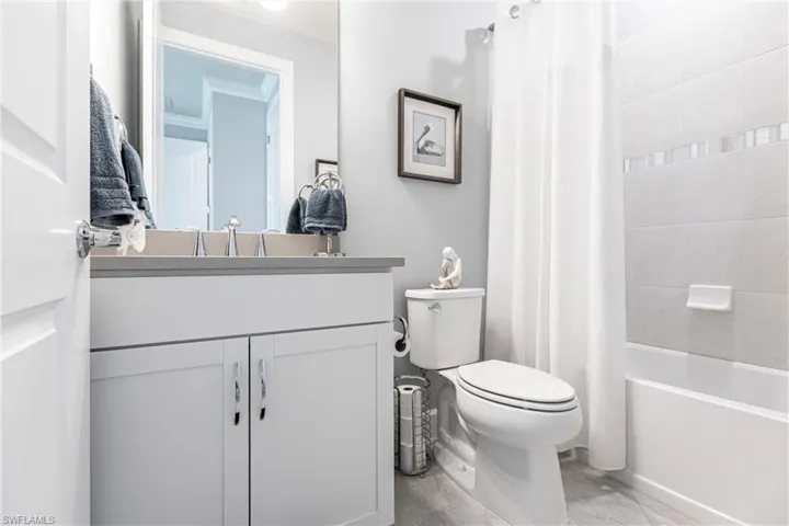 Full bathroom with vanity, toilet, and shower / bathtub combination with curtain