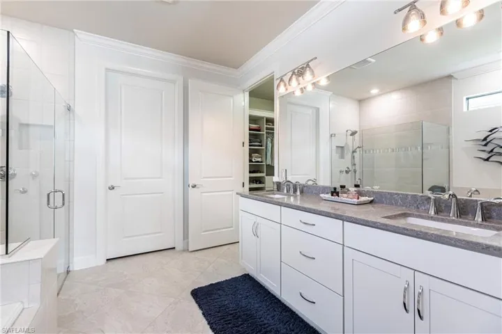 Bathroom with vanity, an enclosed shower, and ornamental molding