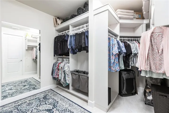 View of walk in closet with custom build uts