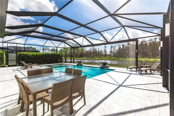 View of pool with a patio, a lanai, an in ground hot tub, and a water view