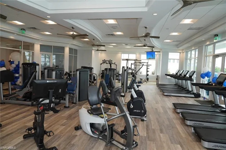 Gym featuring ceiling fan, hardwood / wood-style floors, and ornamental molding