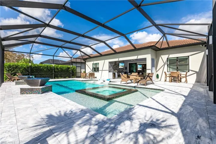 View of pool featuring an in ground hot tub, a patio, and a lanai