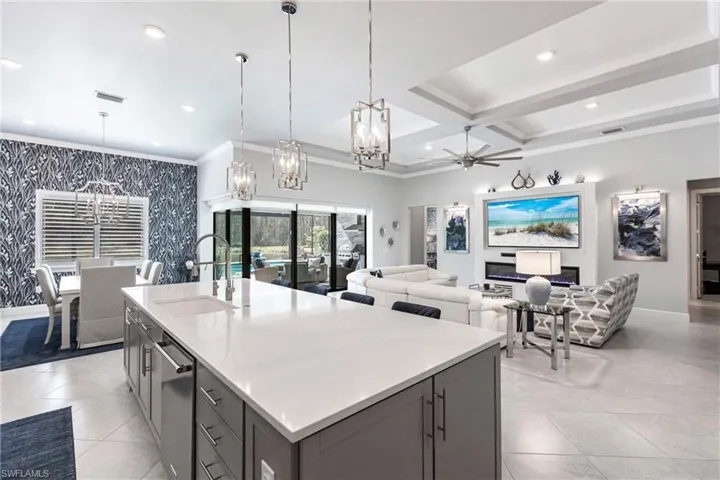 Kitchen featuring pendant lighting, a center island with sink, ceiling fan, and sink