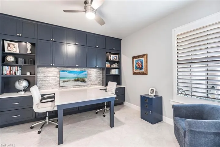 Tiled office featuring built in desk and ceiling fan
