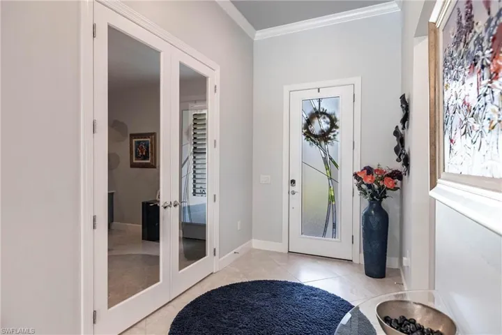 Tiled foyer entrance featuring french doors and ornamental molding