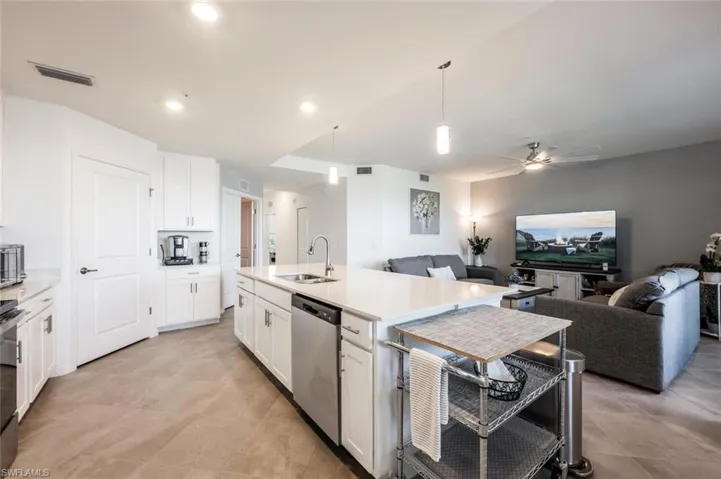 Kitchen featuring visible vents, a sink, range with electric stovetop, stainless steel dishwasher, and open floor plan