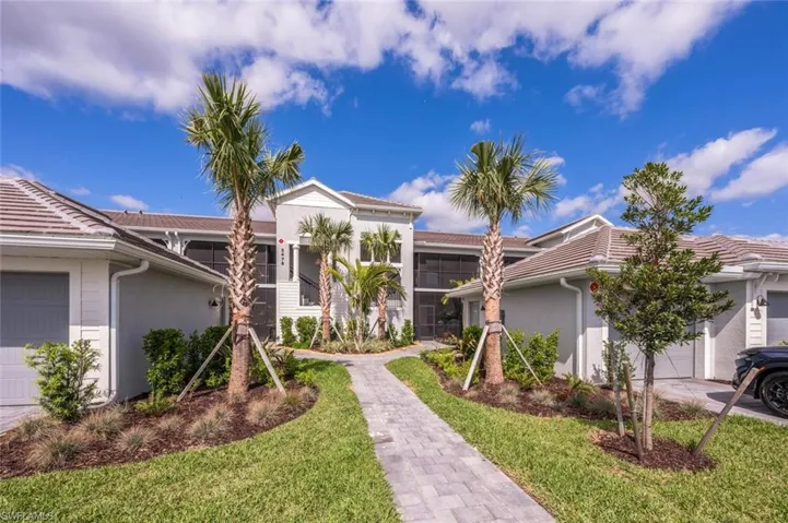 View of front of property featuring a garage, a front lawn, stucco siding, and a tile roof
