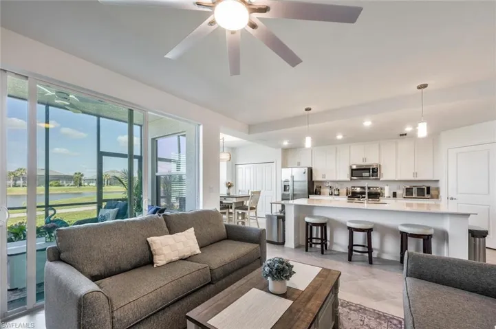 Living area with light tile patterned flooring, recessed lighting, and ceiling fan
