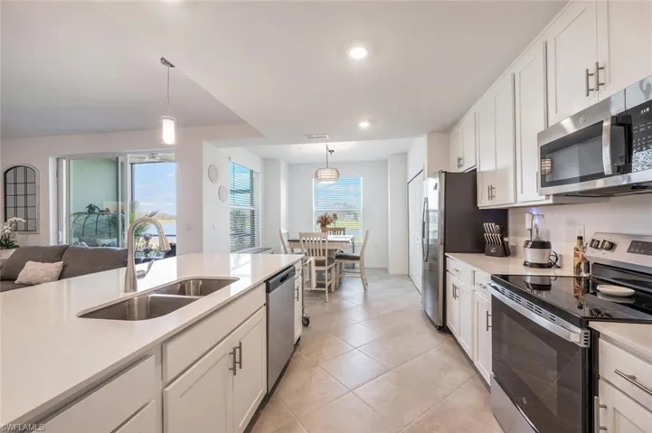Kitchen with a sink, light countertops, white cabinetry, and stainless steel appliances