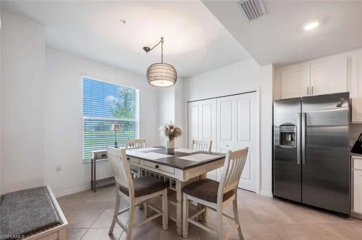 Dining space featuring light tile patterned floors, visible vents, and baseboards