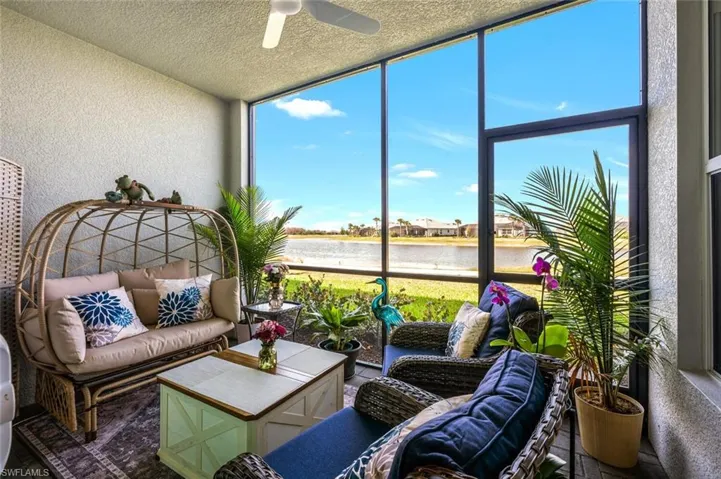 Sunroom / solarium with ceiling fan and a water view