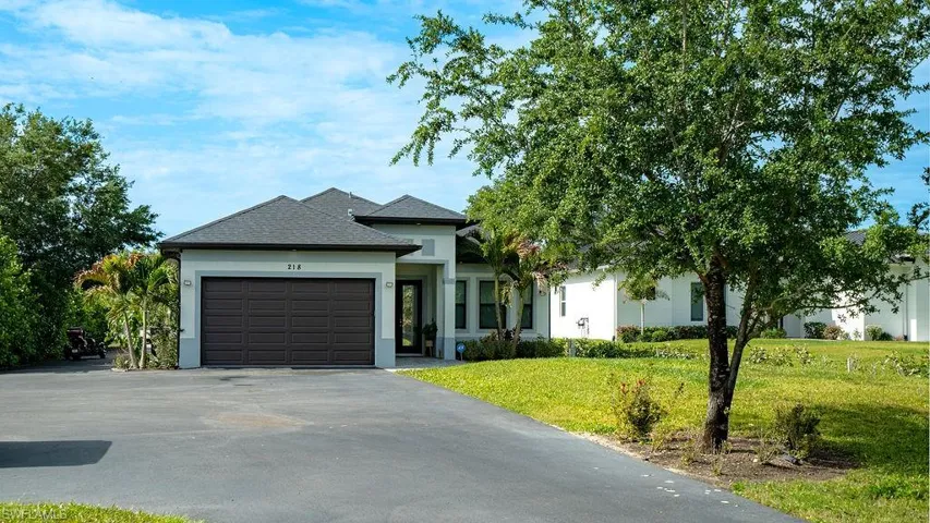 Contemporary single-story residence featuring a dark gray shingle roof and light gray stucco exterior