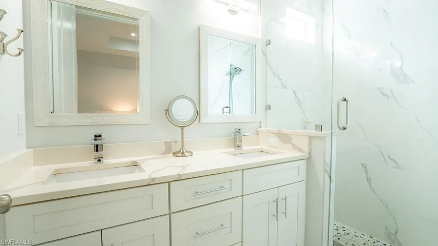Double vanity with light-toned countertops and undermount sinks