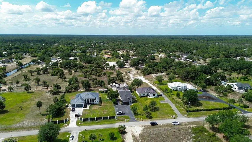 Expansive aerial view showcasing residential properties amidst a verdant landscape